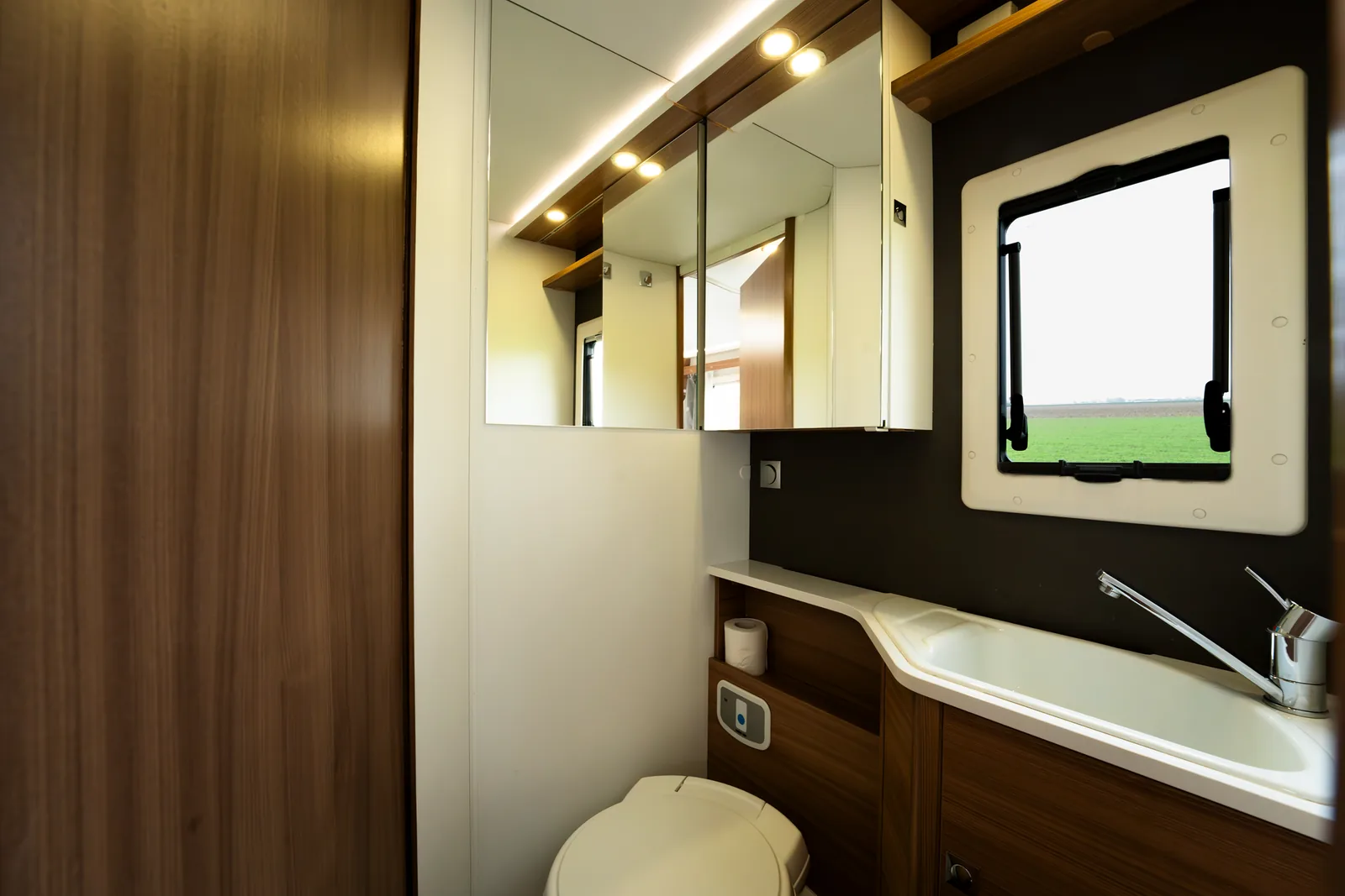 Badkamer met wastafel, spiegelkast en raam