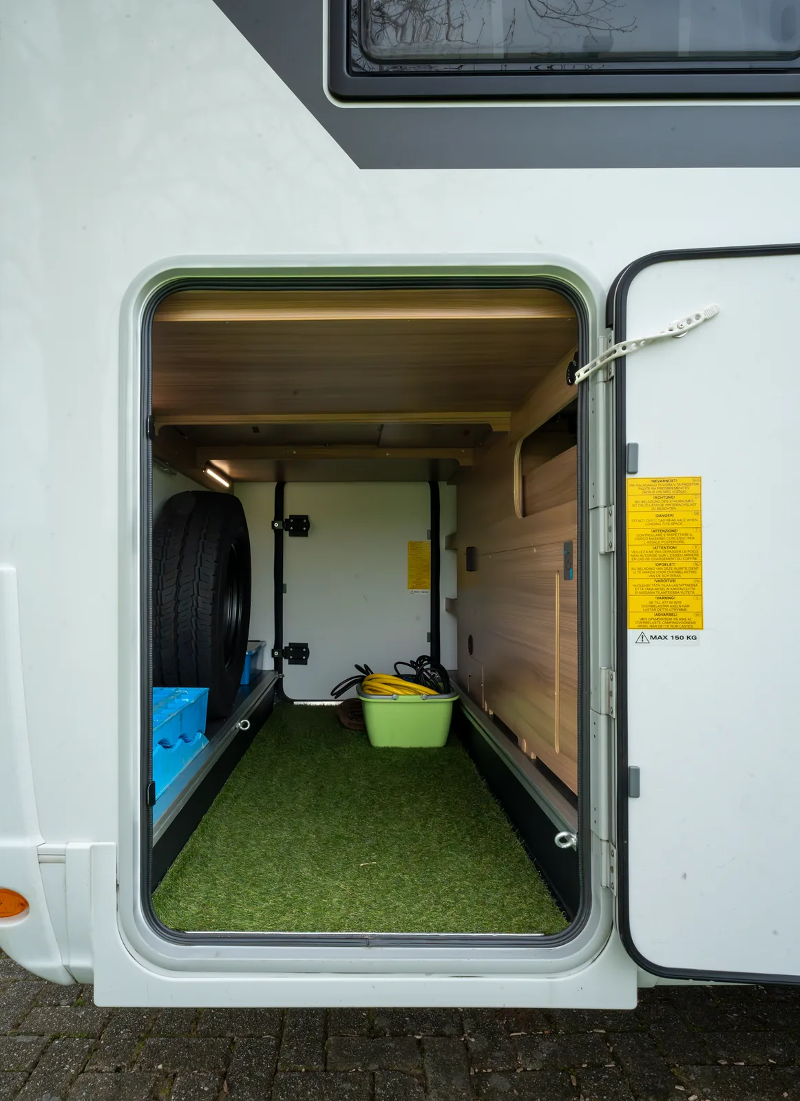 Geopende achtergarage met reservewiel en bergruimte